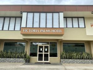 苏瓦Victoria Palms Hotel的一座带有阅读维多利亚棕榈树标志的建筑