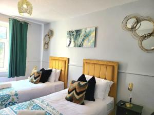 爱丁堡4 Bedrooms Apartment By Sensational Stay Short Lets & Serviced Accommodation的一间卧室配有两张带枕头的床