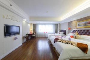 南宁Vienna Intenational Hotel Nanning Zoo Branch的一间酒店客房,设有三张床和一台平面电视