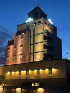 富山Hotel Torni ホテル トルニ的上面有 ⁇ 虹灯标志的建筑