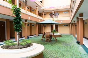邦加槟港Hotel Griya Tirta的大楼内带桌子和遮阳伞的庭院