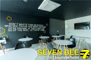 素辇府Seven bee boutique hotel的一间设有桌椅的房间和墙上的标志