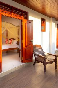 卡卢特勒Holiday Home Kalutara的隔壁的房间,配有一张床和椅子