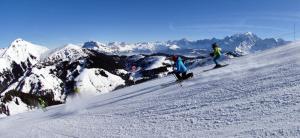 圣母贝莱克Résidence Le Zenith - Studio pour 4 Personnes 384的两个人在雪覆盖的山里滑雪