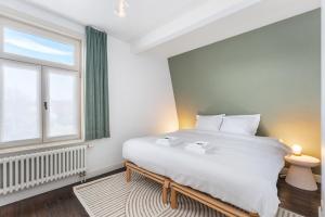 东代恩凯尔克Magique 31 - Luxeverblijf met tuin & parking的卧室设有一张白色大床和一扇窗户。