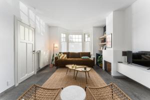 东代恩凯尔克Magique 31 - Luxeverblijf met tuin & parking的客厅配有沙发和桌子