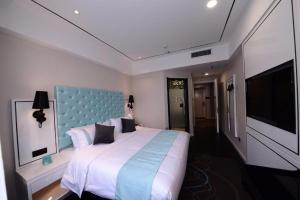 YufaXana Lite Hotel Beijing Daxing International Airport的一间卧室配有一张大床和蓝色床头板