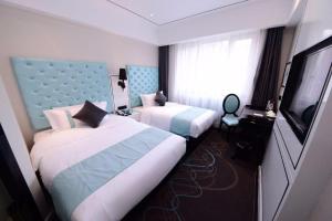 YufaXana Lite Hotel Beijing Daxing International Airport的酒店客房设有两张床和一台平面电视。