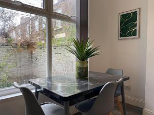 利物浦Huge Home With Street Parking的餐桌、椅子和盆栽