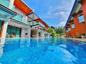 宋卡The Bed Vacation Rajamangala Hotel的大楼前的大型游泳池
