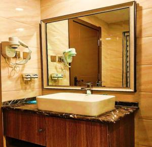 银川PAI Hotels·Yinchuan International Trade City的一间带水槽和大镜子的浴室