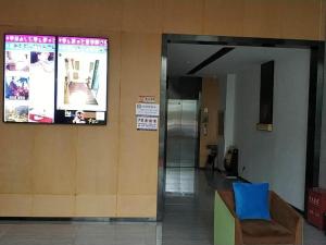 威宁IU Hotels·Bijie Weining Caohai Railway Station的大楼的大堂,墙上配有电视
