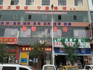 威宁IU Hotels·Bijie Weining Caohai Railway Station的街道一侧有标志的建筑