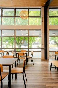 罗托鲁瓦Haka House Rotorua的一间设有桌椅和窗户的自助餐厅