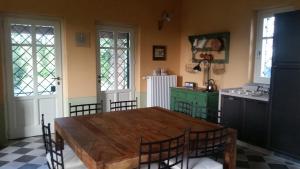 Rocchetta TanaroCascina Rollone的一间带木桌的用餐室和一间厨房