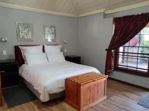 MachadodorpThe Grey's Inn的一间卧室设有一张大床和一个窗户。