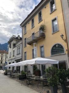 多莫多索拉Palazzo 7的前面有桌子和伞的建筑