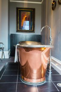 伊利诗人之家酒店的浴室内设有带水龙头的铜浴缸