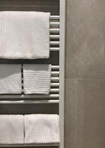 多莫多索拉Palazzo 7的浴室内架上的一束白色毛巾
