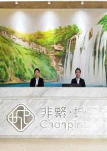 安顺Chonpines Hotels·Anshun Taixiang Baili的两个穿着西服的男人坐在瀑布前的桌子上