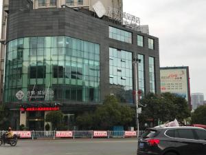 安顺Chonpines Hotels·Anshun Taixiang Baili的停在大楼前的汽车