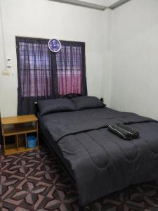 Ban Hua ThaleChainarong Road的一间卧室配有一张带窗户时钟的床
