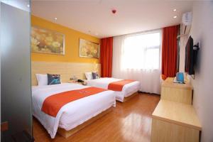渝北PAI Hotel·Chongqing Jiangbei Airport Changfu Road Light Rail Station的酒店客房设有两张床和电视。