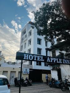 艾哈迈达巴德Hotel Apple Inn的摩托车停在大楼前的酒店