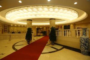 呼和浩特Vienna Hotel Inner Mongolia Hohhot Railway Station Gongzhufu Metro Station的一个大大堂,铺有红地毯,设有大天花板