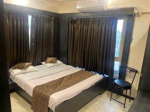 艾哈迈达巴德Hotel Apple Inn的一间卧室配有床和带窗帘的窗户