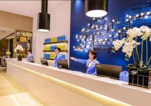 贵阳Echarm Hotel Guiyang Longdongbao International Airport Outlets的一群人站在商店的柜台上