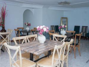 乌姆塔塔Elam Guest House的一张带椅子的木桌和花瓶