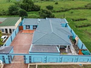 乌姆塔塔Elam Guest House的享有蓝色房屋的顶部景致,设有太阳能电池板
