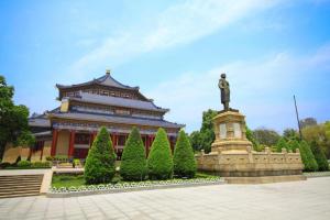 广州Ying Feng Yuan Hotel的一座大建筑,前面有雕像