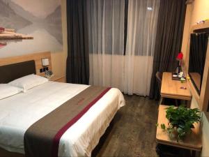 山后街Thank Inn Hotel Anhui Chuzhou Fengyang County Bus Station的酒店客房设有一张大床和一张书桌。