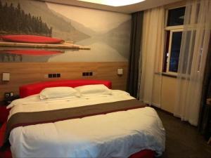 山后街Thank Inn Hotel Anhui Chuzhou Fengyang County Bus Station的卧室配有一张大床,墙上挂有绘画作品