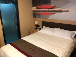 山后街Thank Inn Hotel Anhui Chuzhou Fengyang County Bus Station的卧室配有白色的床和蓝色的门