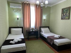 希瓦Hotel Euro Asia Khiva in Ichan Qala的酒店客房设有两张床和窗户。