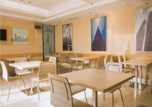 长沙City Comfort Inn Changsha Wuyi Avenue Yingbin Road的一间带桌椅和绘画的用餐室