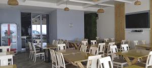 希马拉Anxhelos Hotel的用餐室配有桌椅和平面电视。