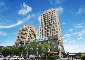 南宁City Comfort Inn Nanning Haijixing Jiangnan Park Metro Station的两座高楼,有车停在停车场