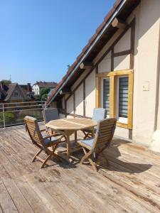 贝尔福Appartement-terrasse parking privé Meublé de Tourisme 4 étoiles的木制甲板上的木桌和椅子