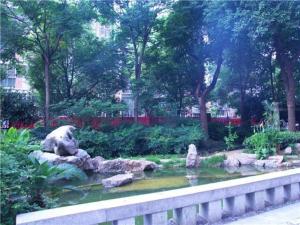 黄石City Comfort Inn Huangshi Wanda Plaza Huashan Road的花园内有一个池塘,里面有一个熊