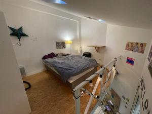 庞坦Maisonnette en duplex 25 M2, Pantin porte de Paris的一间小卧室,配有一张床和一个楼梯