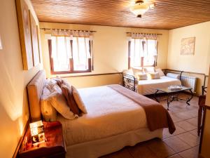 拉斯卡弗里亚钟楼旅馆的一间卧室配有一张床、一张桌子和两个窗户
