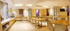 贵阳City Comfort Inn Guiyang Jiefang Road Hongtongcheng的用餐室配有木桌和椅子