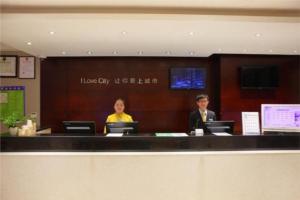 贵阳City Comfort Inn Guiyang Jiefang Road Hongtongcheng的两人坐在大堂的柜台