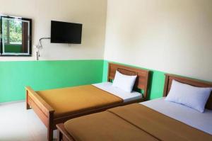 丹戎潘丹Hotel Meigah的客房设有两张床和一台平面电视。
