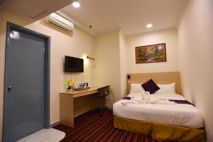 吉隆坡hotel bintang的配有一张床和一张书桌的酒店客房