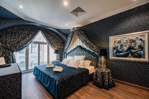布达佩斯Celine Residence Luxury的卧室配有蓝色的床和墙上的绘画作品